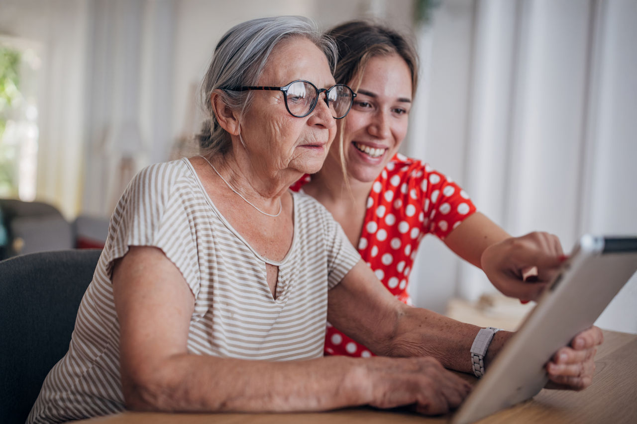 Senior citizen getting computer help.